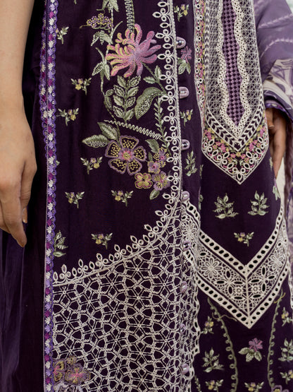 Close-up of a dark purple fabric with intricate white embroidery and floral patterns.