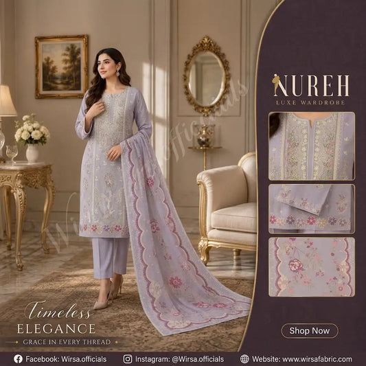 Detailed view of Nureh Luxe Wardrobe unstitched 3-piece lavender suit kit. Includes the main kurta fabric with intricate multi-color floral embroidery, a matching unstitched sleeve panel, folded solid lavender trouser fabric, and a large printed chiffon dupatta. Flanked by golden lamps and vases in a luxurious room setting.