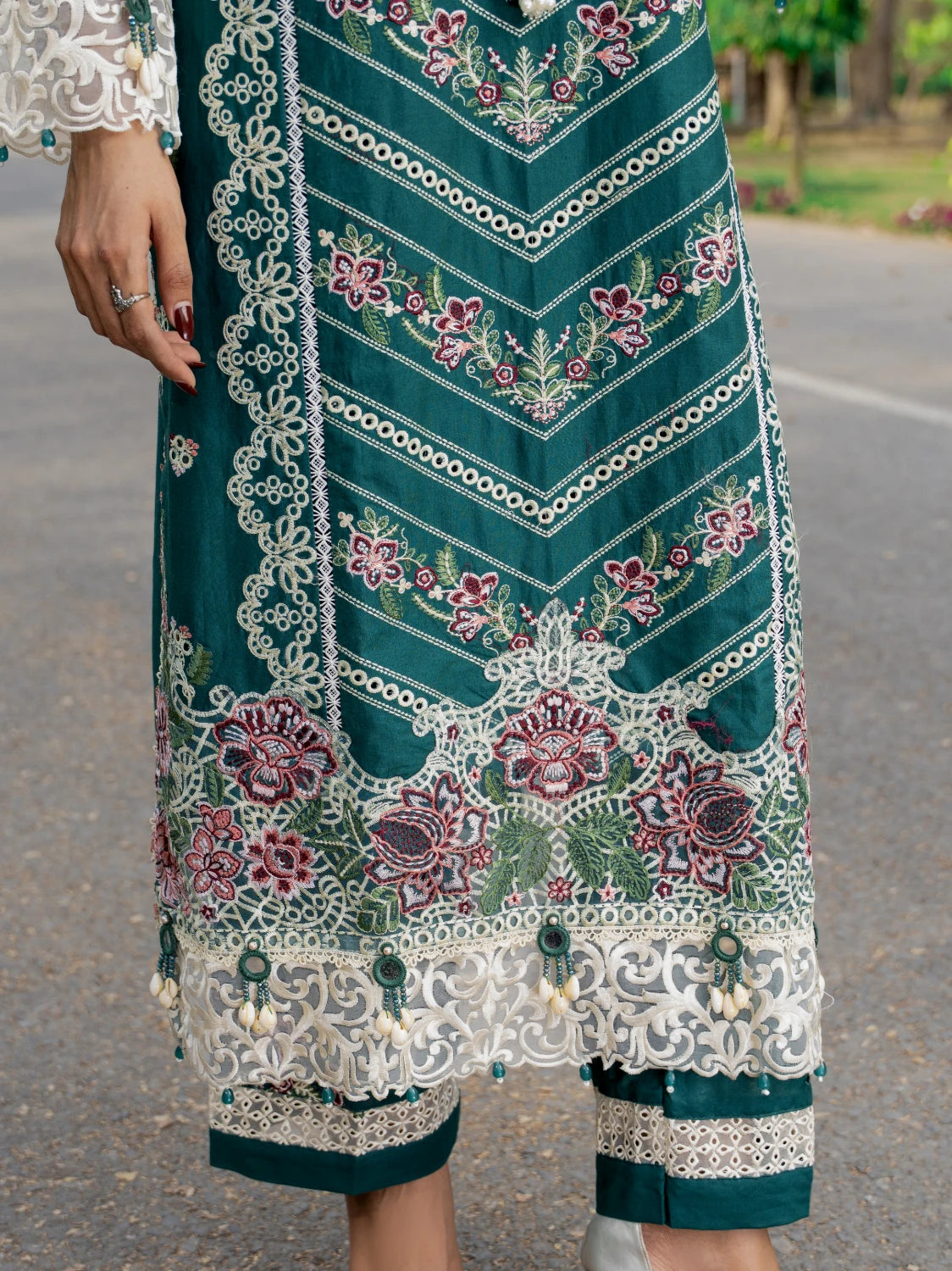 Traditional embroidered garment with intricate patterns on a blurred outdoor background