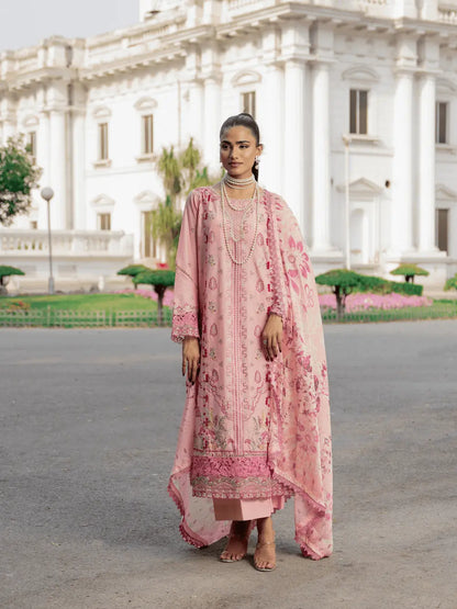 Woman in a pink traditional outfit standing in front of a large white building.